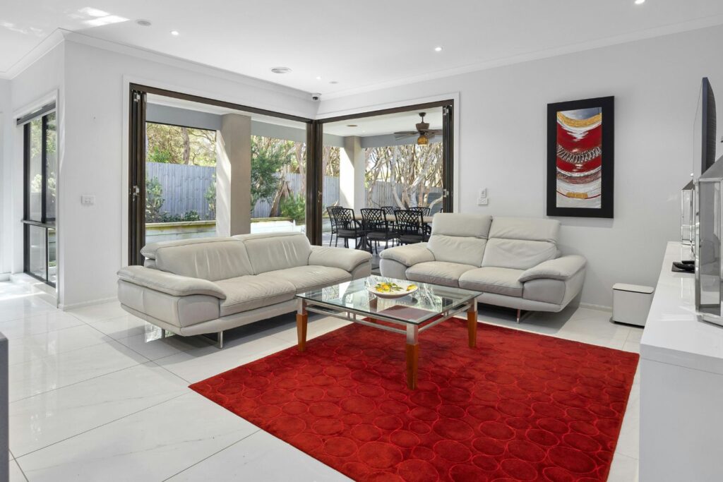 Modern living room with white sofas and red rug after deep cleaning services in New Jersey